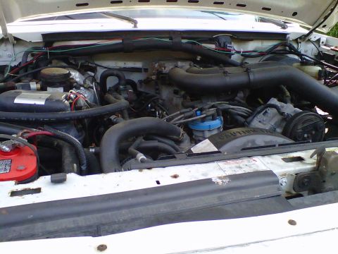 1995 Ford C-350 (Centurion Conversions) - Close-up view of the engine compartment, showing various mechanical parts and wiring.