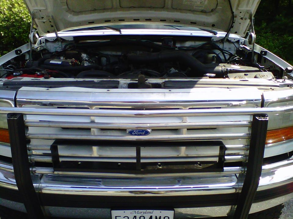 Ford truck engine bay with hood open, showing engine and front grille with bull bar