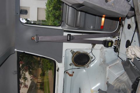 1994 Ford Bronco - Interior view of a vehicle, showing an exposed speaker and seatbelt mechanism. Supermotors.net logo is visible.