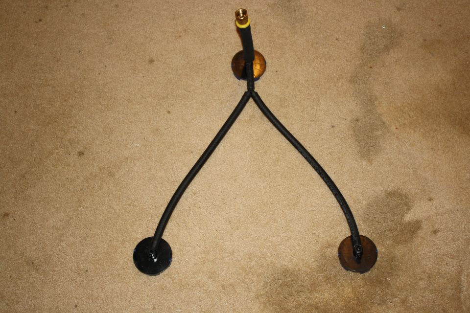 Fuel lines with brass fitting and two black circular mounts on carpet
