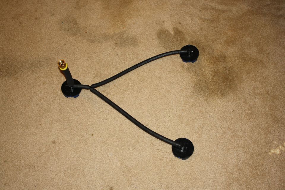 Spark plug wire set with three black wires and brass connector on carpet