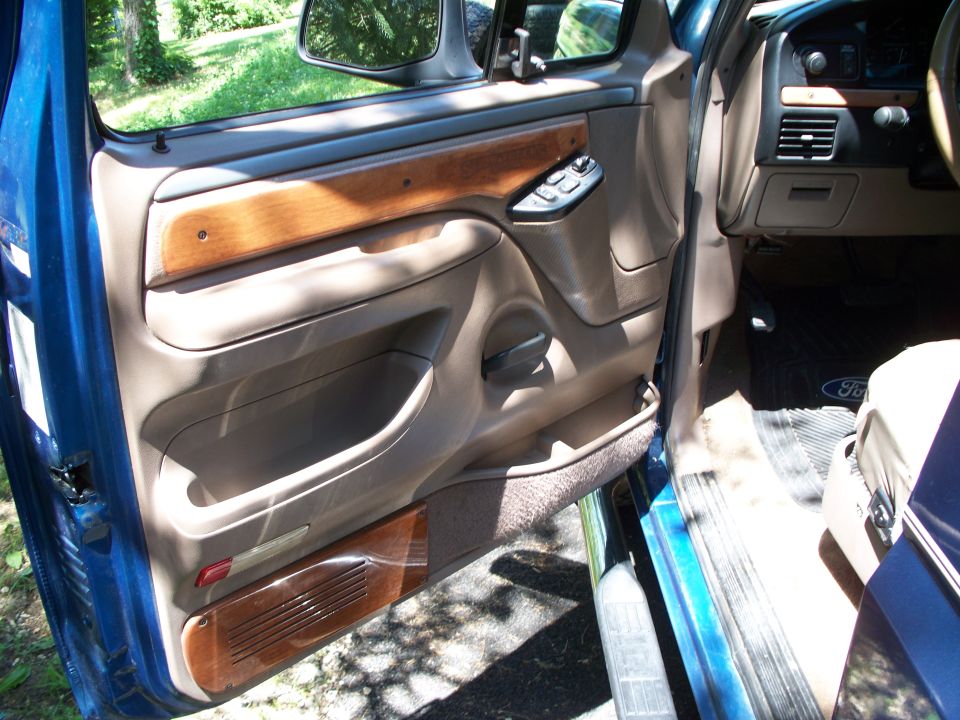 1995 Ford Bronco interior door panel with wood trim and power window controls