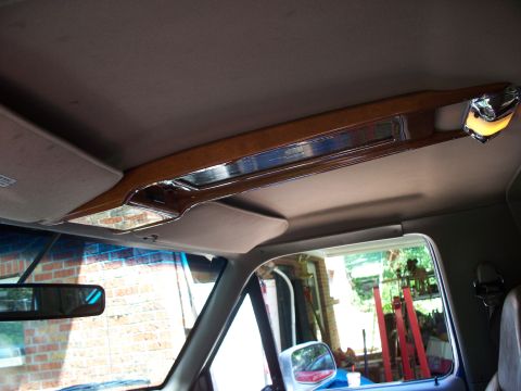 1995 Ford Bronco - The wood-trimmed overhead console and interior lighting of a 1995 Ford Bronco.