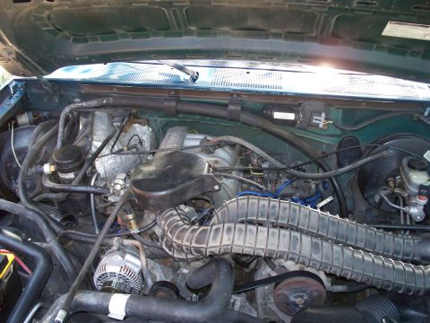 1995 Ford Bronco - The engine bay of a 1995 Ford Bronco is visible, with various components like the V8 engine and air intake clearly depicted.