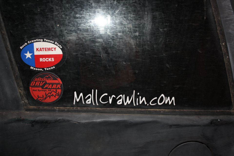 Black vehicle window with two stickers and a website name