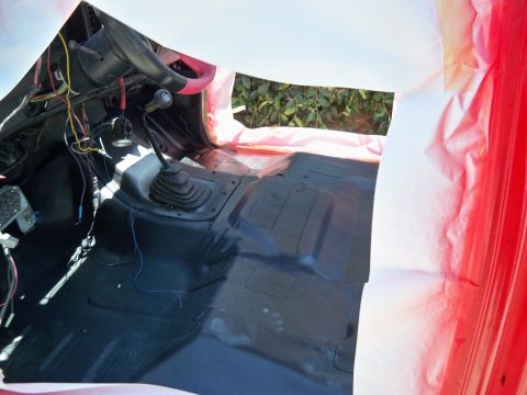1985 Ford Bronco - The interior of a vehicle is being prepared for painting, with masking tape and plastic sheeting visible.