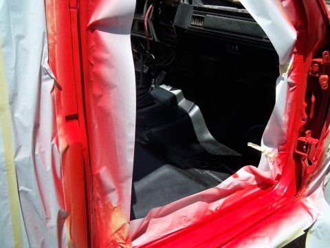 1985 Ford Bronco - Spray painting the interior of a vehicle, with masking tape covering areas not to be painted.