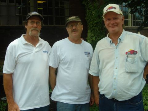 1975 Ford Ranchero - Three men pose for a photo outside a building, with one man wearing a shirt a car graphic.