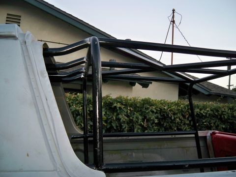 1985 Ford Bronco - A custom black metal rack is mounted inside the bed of a white pickup truck.