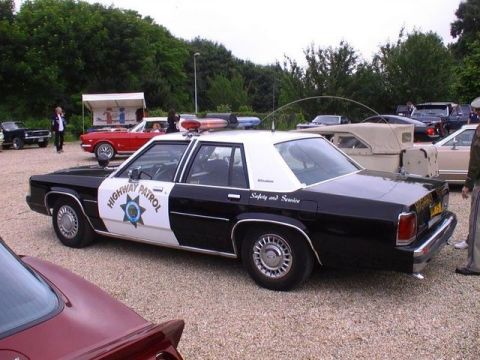 1991 Ford Crown Victoria - A police car with 'Highway Patrol' and 'Safety and Service' text is parked outdoors with other vehicles.