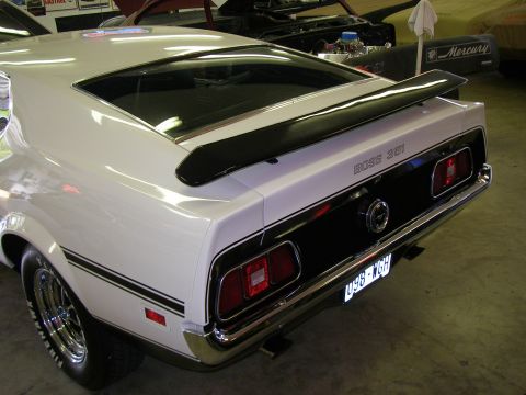 1971 Ford Mustang - The rear of a white 1971 Ford Mustang Boss 351 is shown, a black stripe and spoiler detail.