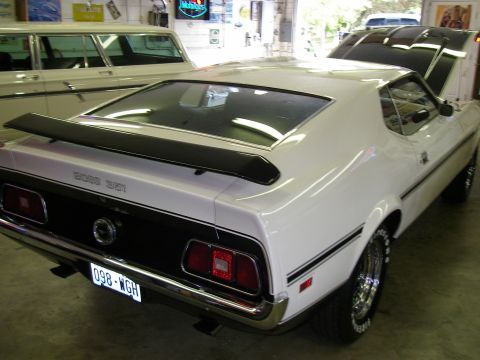 1971 Ford Mustang - Rear view of a white 1971 Ford Mustang Boss 351 with black racing stripes and a rear spoiler.