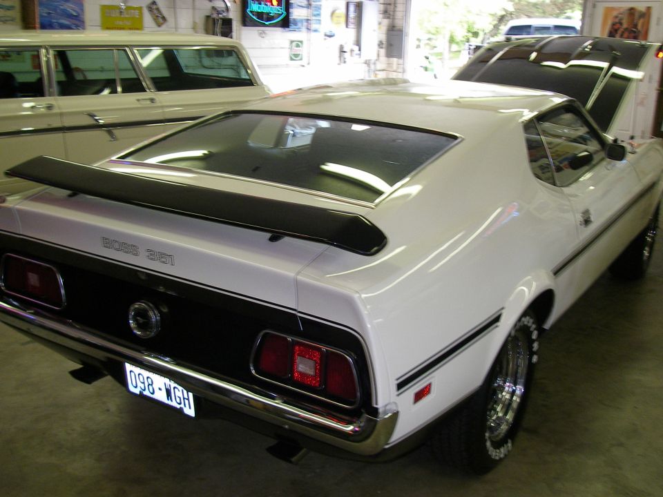 White 1971 Ford Mustang Boss 351 rear quarter view with black stripe and spoiler. License plate 098-WGH
