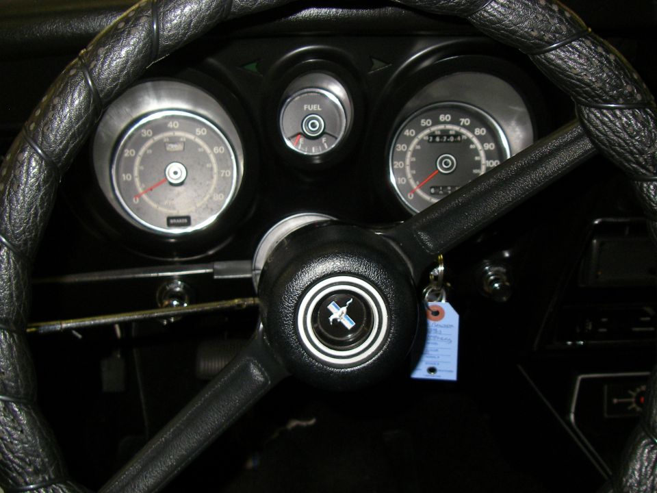 1971 Ford Mustang interior showing dashboard gauges and steering wheel with Mustang logo