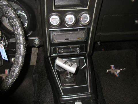 1971 Ford Mustang - The interior of a 1971 Ford Mustang shows the dashboard, floor shifter, and a floor mat with the iconic running horse emblem.