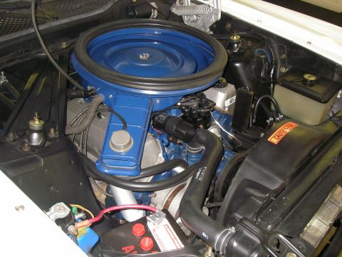 1971 Ford Mustang - Engine bay view of a 1971 Ford Mustang, its blue air cleaner assembly and a "CAUTION FAN" warning label.