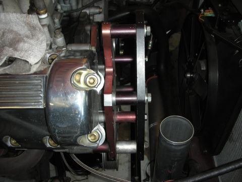 1992 Ford Crown Victoria - Close-up view of a chrome engine component with red spacers and bolts, part of an engine rebuild.