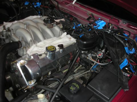 1992 Ford Crown Victoria - The engine bay is partially disassembled, with various parts covered and wires secured with blue tape.