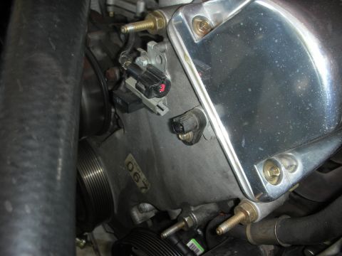 1992 Ford Crown Victoria - Close-up of engine components, including sensors and a shiny chrome cover, with a partial part number visible.