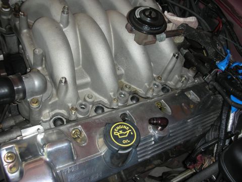1992 Ford Crown Victoria - Close-up of an engine's intake manifold and valve cover, which is labeled 'The Rocket Cough'.