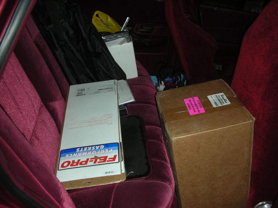Boxes and Fel-Pro performance gaskets on burgundy car seats