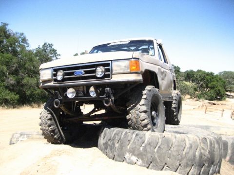 1989 Ford Bronco - Modified 1989 Ford Bronco navigating an obstacle on an off-road course.
