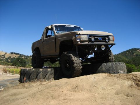 1989 Ford Bronco - This modified truck is positioned on large tires, demonstrating its off-road capabilities on a sunny day.