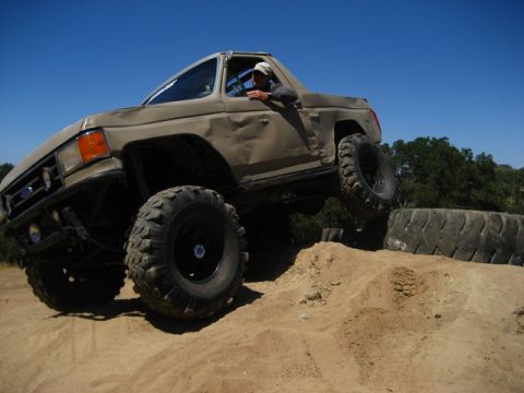 1989 Ford Bronco - Modified 1989 Ford Bronco tackling an obstacle on a dirt course.