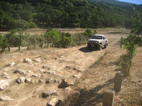 1989 Ford Bronco - Pickup truck navigates a challenging off-road course with rocky terrain.