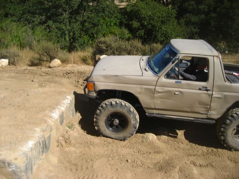 1989 Ford Bronco - This modified Ford Bronco navigates a challenging off-road course, demonstrating its capabilities.