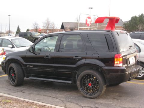 1996 Ford Bronco - This black SUV has aftermarket wheels and a prominent red spoiler mounted on its roof.