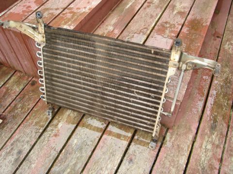 1989 Ford Bronco - A car radiator part is shown resting on weathered wooden planks.