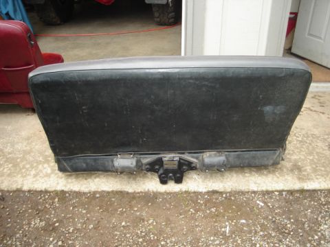 1989 Ford Bronco - A black rear bumper assembly with a trailer hitch is shown in front of a garage door.