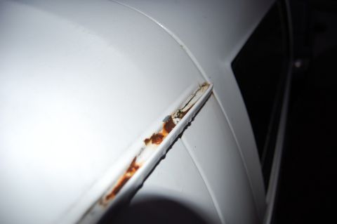 1994 Ford Bronco - Close-up of rusted trim on a white vehicle.