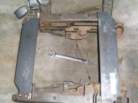 1996 Dodge 2500 - A seat frame mechanism is shown on a carpeted surface, with a wrench resting on the metal components.