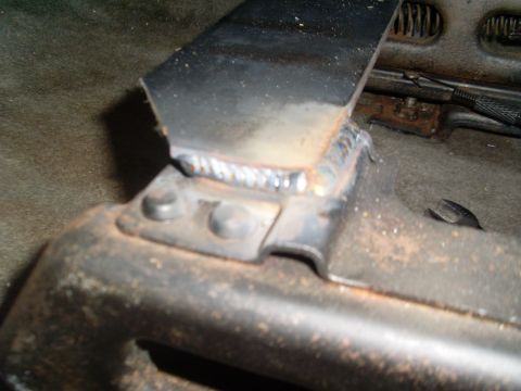 1996 Dodge 2500 - A metal bracket has been welded to the seat frame, showing visible weld marks and rust.