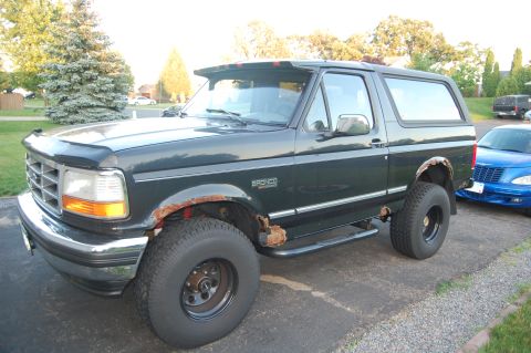 1994 Ford Bronco - This 1994 Ford Bronco is shown from a 3/4 front angle, revealing rust damage on its body panels and wheel wells.