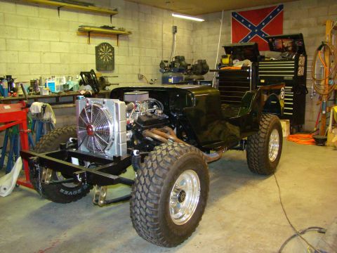 1948 Jeep Wrangler - Jeep CJ-5 body and chassis in a garage, with engine and radiator visible. Restoration in progress.