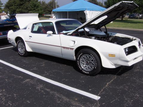 1977 Pontiac Trans Am - A white 1977 Pontiac Trans Am is parked with its hood open, showing the engine bay.