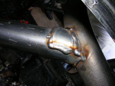 1989 Ford Escort - Close-up view of welded metal tubing, showing signs of rust and discoloration.