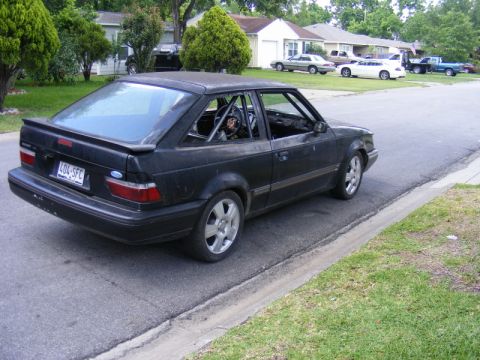 1989 Ford Escort - Modified 1989 Ford Escort hatchback with a roll cage visible through the windows.