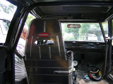 1989 Ford Escort - The interior of a race car features a Kirkey racing seat and a prominent roll cage, suggesting a focus on performance and safety.