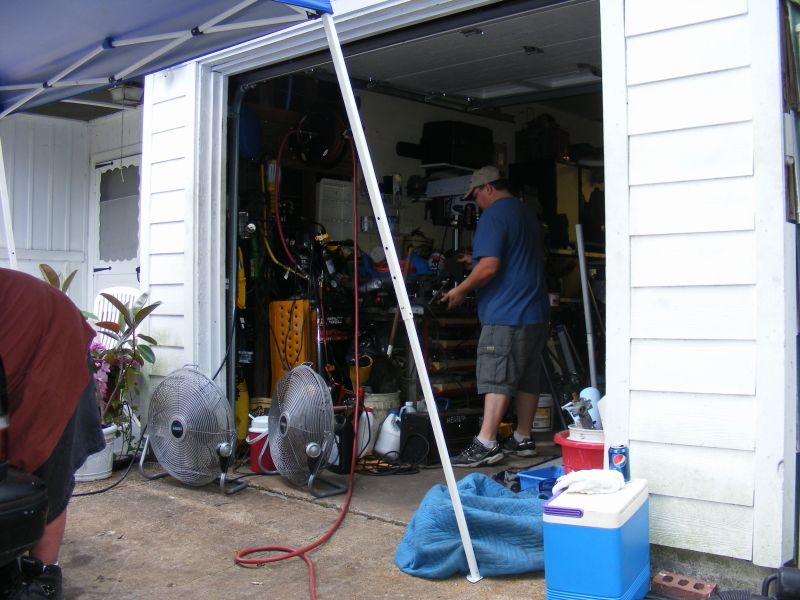Garage interior with tools, fans, and a person working