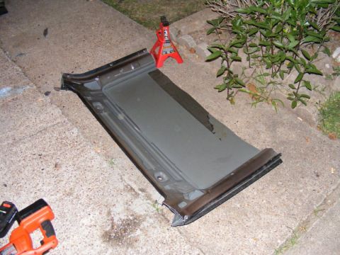 1989 Ford Escort - Car door panel removed and placed on the ground next to a jack stand.