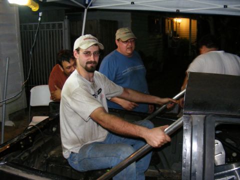 1989 Ford Escort - Men are working inside a car that appears to be undergoing modifications or repairs.