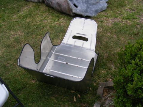 1989 Ford Escort - An aluminum racing seat is shown outdoors on a grassy area next to a bush.