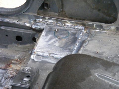 1989 Ford Escort - Close-up of a vehicle's interior floor pan showing recent welding repairs and some rust damage.