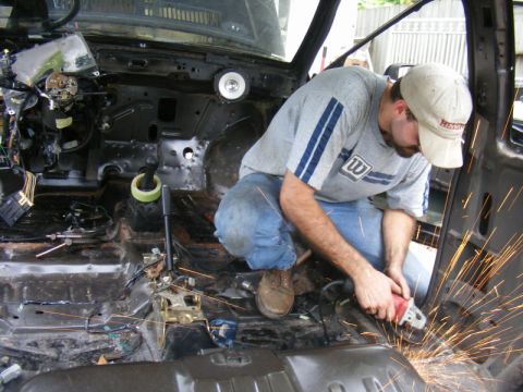 1989 Ford Escort - Working on the interior of a vehicle, sparks fly as metal is ground.