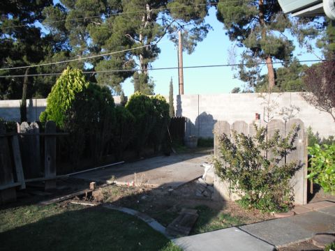 1991 Ford Bronco - A view of a backyard area with a concrete block wall and a wooden fence.