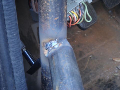1989 Ford Escort - A close-up view shows a welded metal tube and a wiring harness, likely from a vehicle's interior.